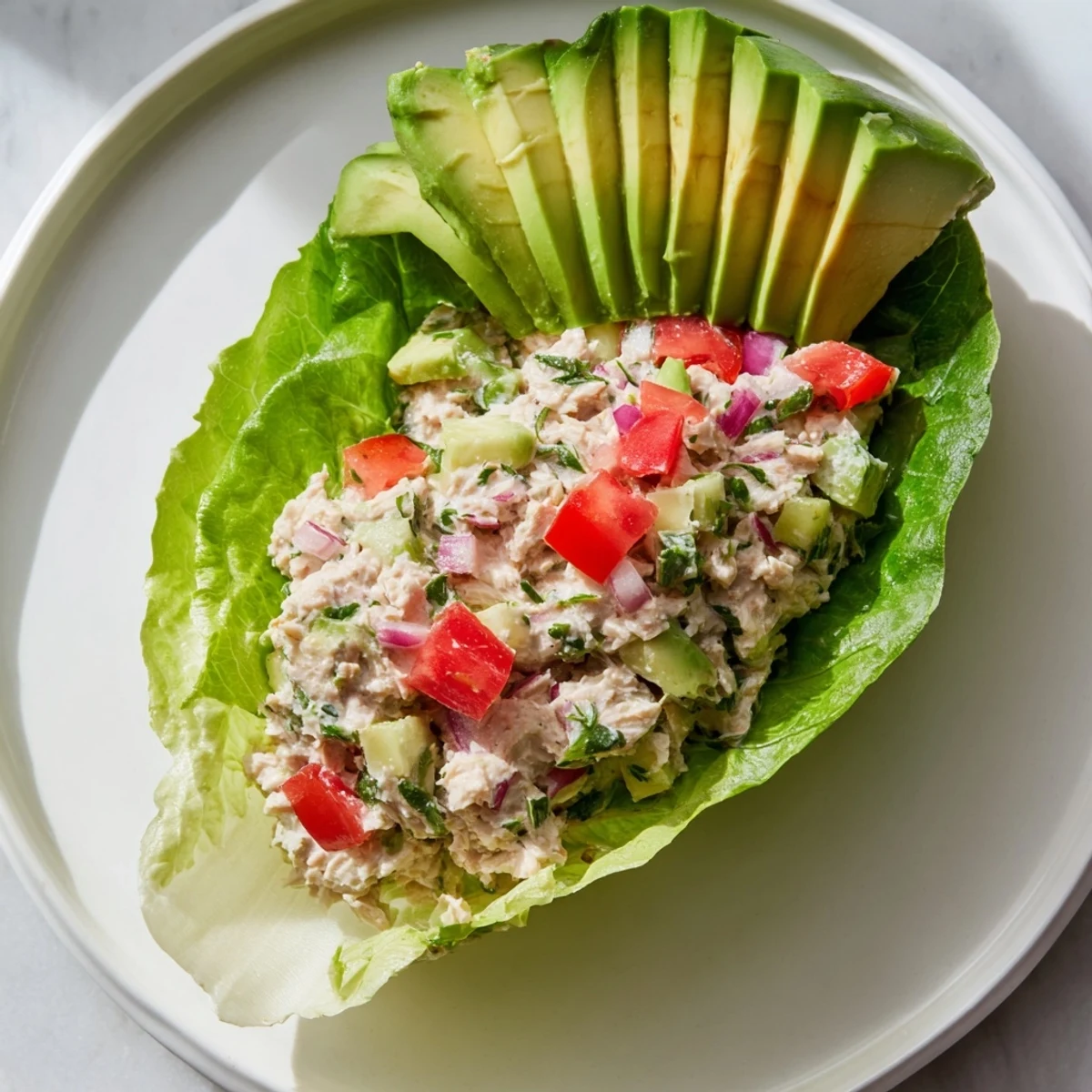 Fresh Quick & Healthy Tuna Salad Lettuce Wraps served with vibrant tomato, offering a light, low-carb lunch option.