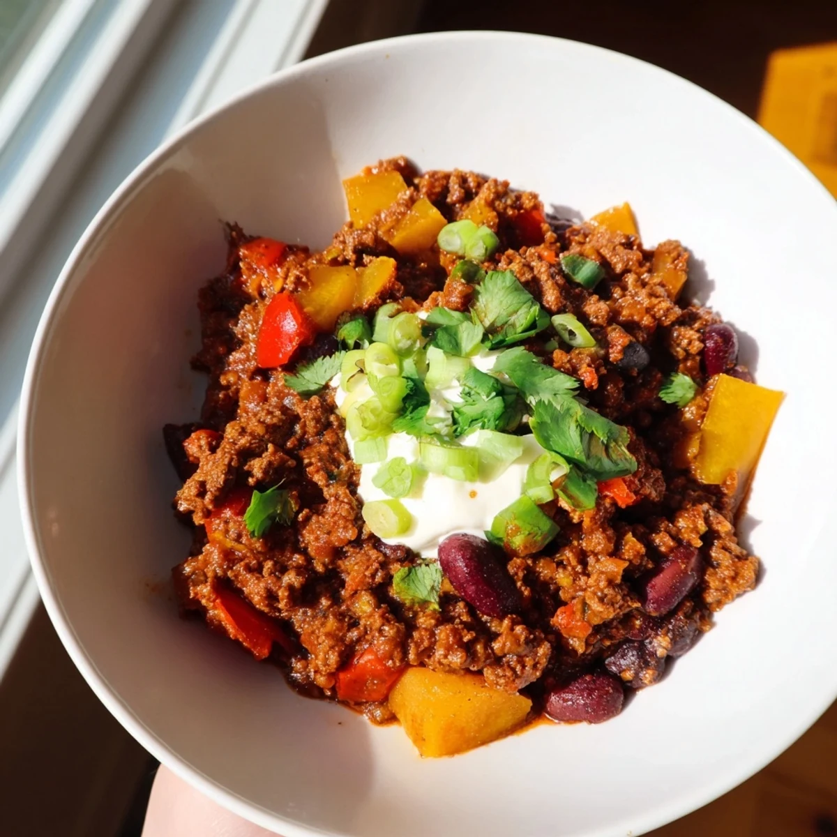 Steaming-hot simple weeknight chili presented with cheese and fresh cilantro, perfectly spiced for dinner.