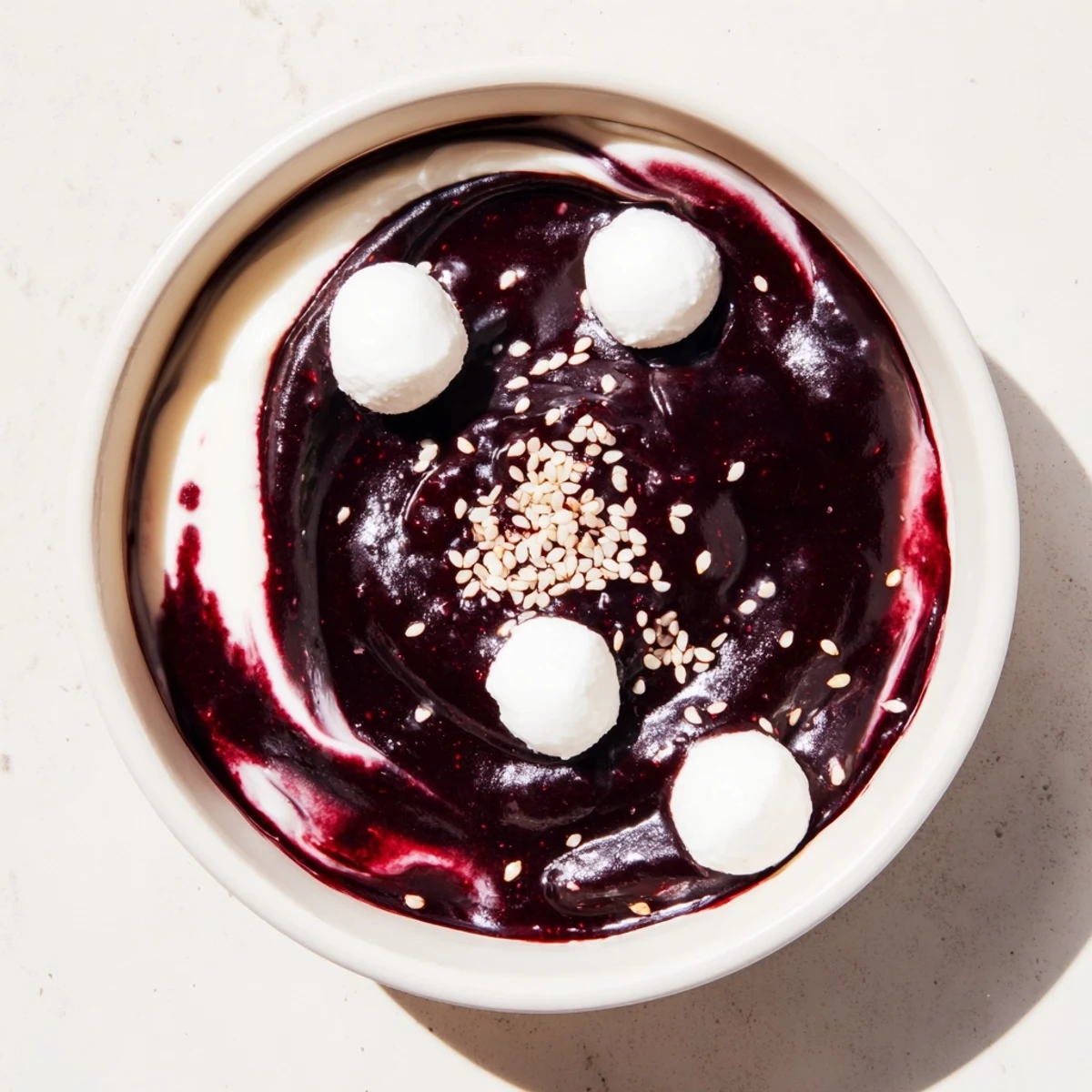 This visually stunning Galaxy Spiral dessert shows a gourmet treat with blackberry jam swirls, goat cheese, and sesame seeds.