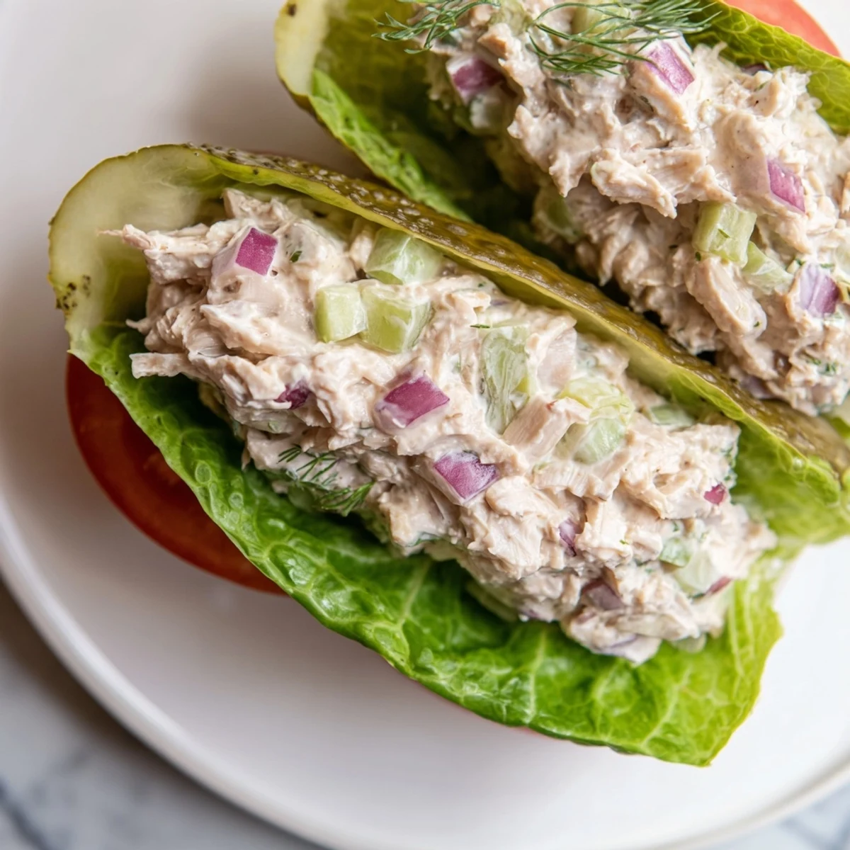 Juicy chicken salad fills a crunchy pickle sandwich, a perfect low-carb lunch with fresh dill.
