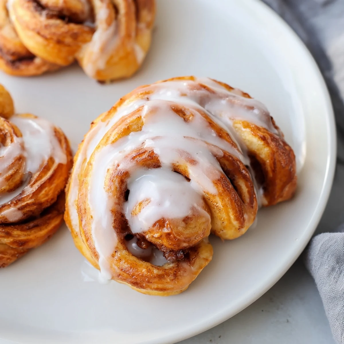 Warm air fryer cinnamon roll twists, glazed and ready to eat for a quick, sweet American breakfast.