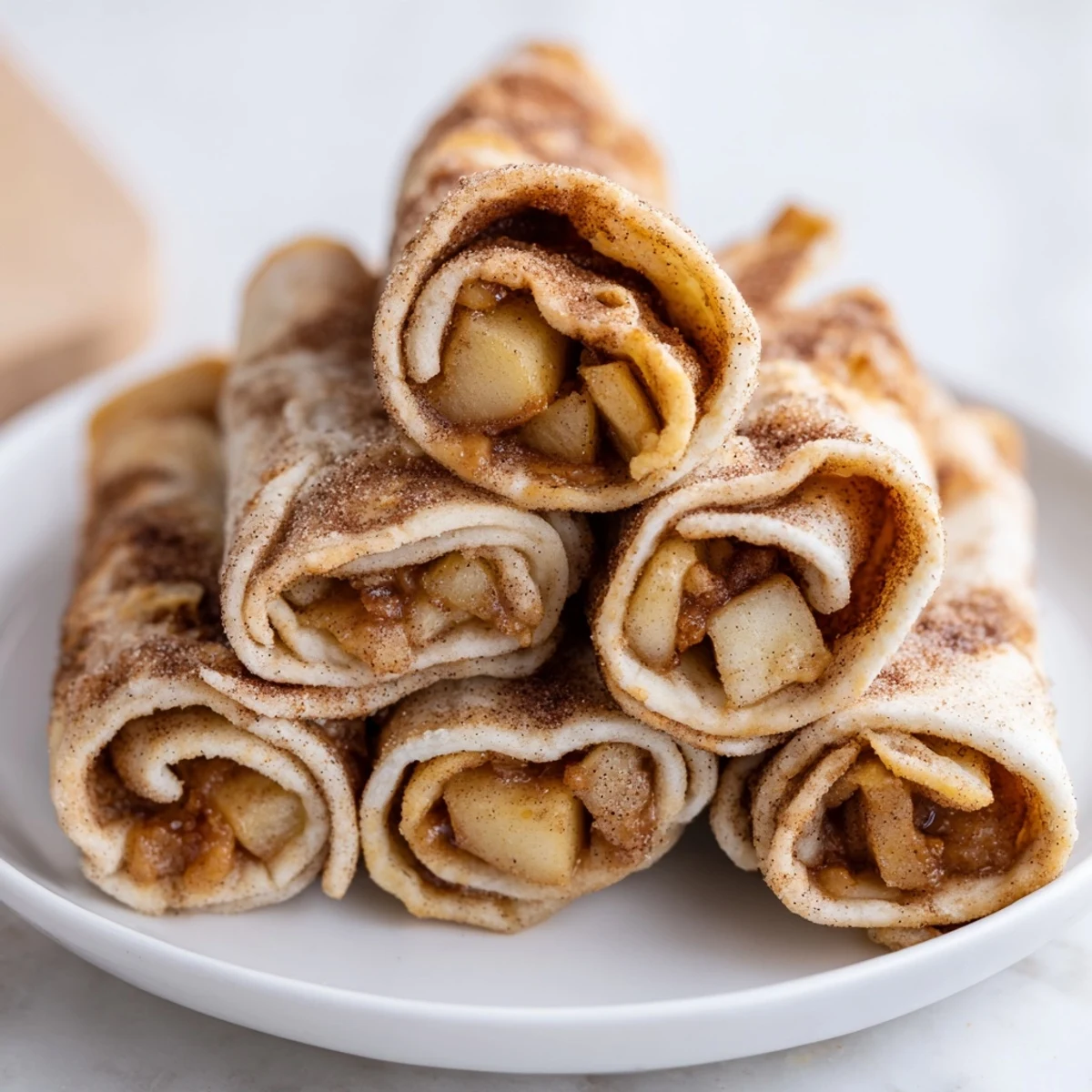 Crispy flour tortillas filled with spiced apples create this tempting Apple Pie Roll-Ups dessert snack.