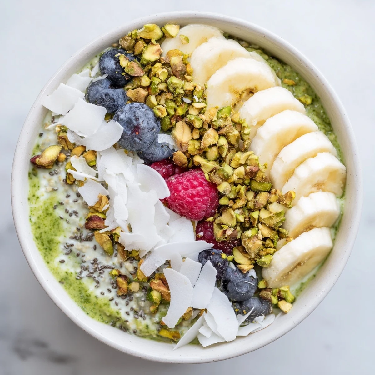 Vibrant green Matcha Overnight Oats topped with fresh berries, ready for a delicious breakfast.