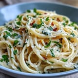 Creamy lemon butter pasta with fresh garlic and Parmesan, served in a white bowl with a sprinkle of parsley.