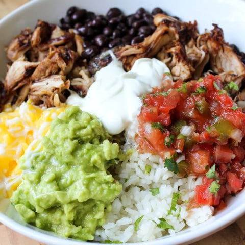Chipotle Burrito Bowl, layered with tender carnitas, creamy queso, and fresh salsa, a delicious meal.