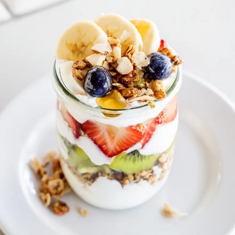 A refreshing Layered Yogurt Fruit Parfait with layers of creamy yogurt and colorful berries, ready to enjoy.