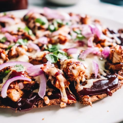 Freshly baked BBQ Chicken Flatbread with gooey mozzarella, tangy BBQ sauce, and fresh cilantro garnish on a wooden board.  
