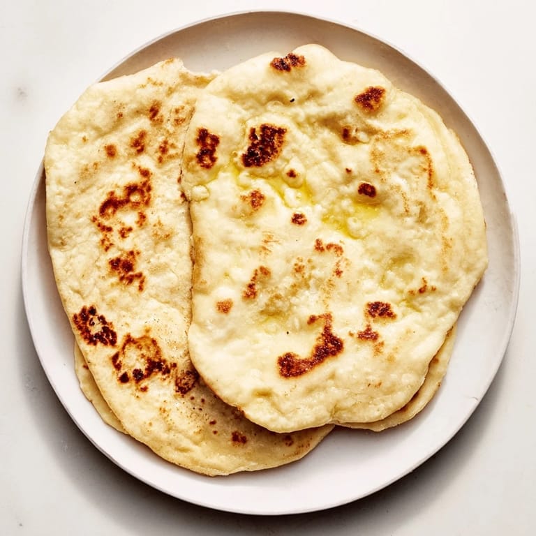 Freshly cooked Three-Ingredient Easy Flatbreads, slightly puffed with appealing, charred spots.