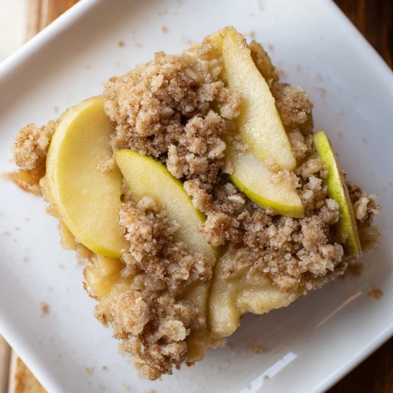 Warm, comforting Rustic Apple and Cinnamon Crumb Bake, served with vanilla ice cream, ready to enjoy.