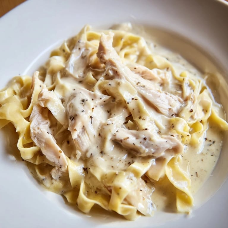A comforting serving of homemade Skillet Chicken Alfredo features creamy sauce, savory chicken, and noodles ready for a quick Italian-American family meal.