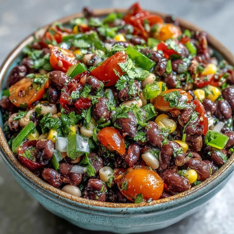 Colorful Cowboy Caviar salad in a white bowl, garnished with fresh cilantro and diced jalapeños, ideal as a refreshing vegetarian dip or side.  